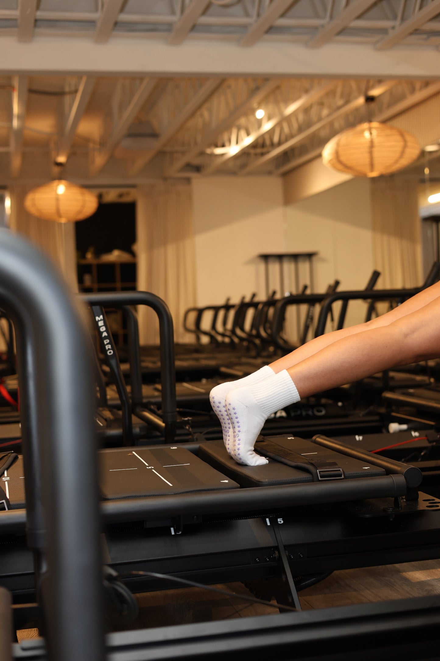 Person on a reformer doing a pilates workout in grip socks.