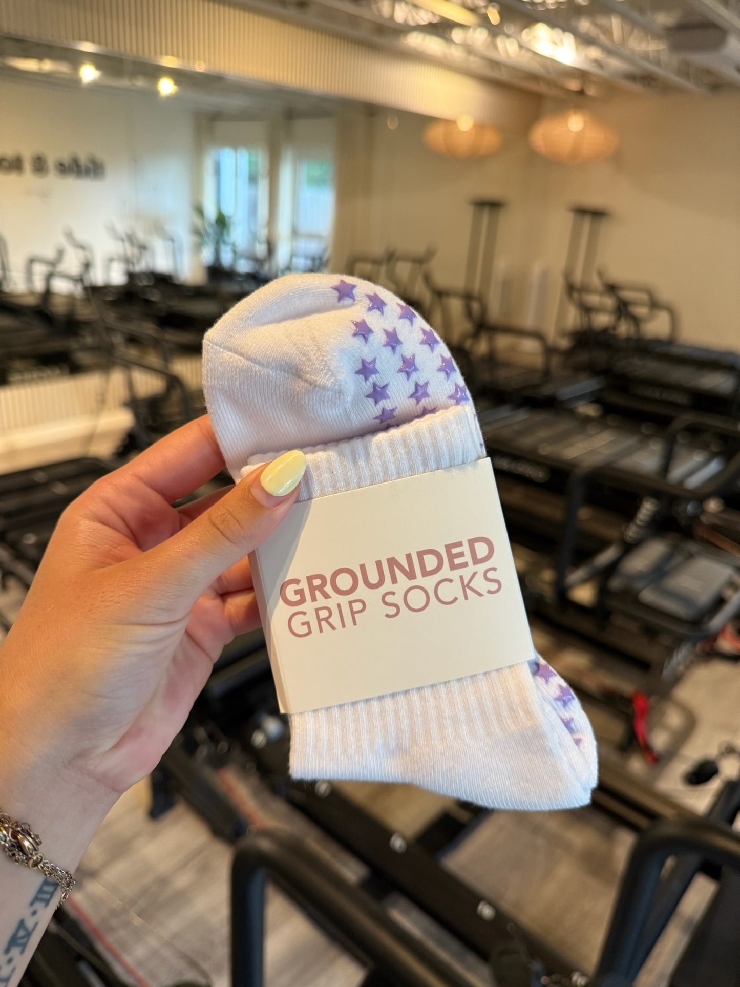 White sock with purple stars held in front of a pilates studio.