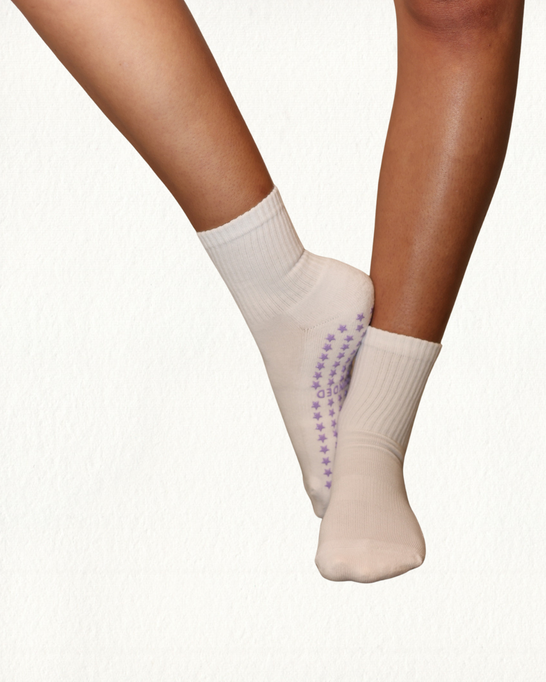 White pilates socks with purple accents on a white background