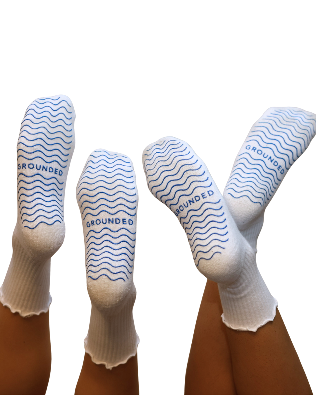 White frilly grip socks with blue patterns and 'GROUNDED' branding on a white background
