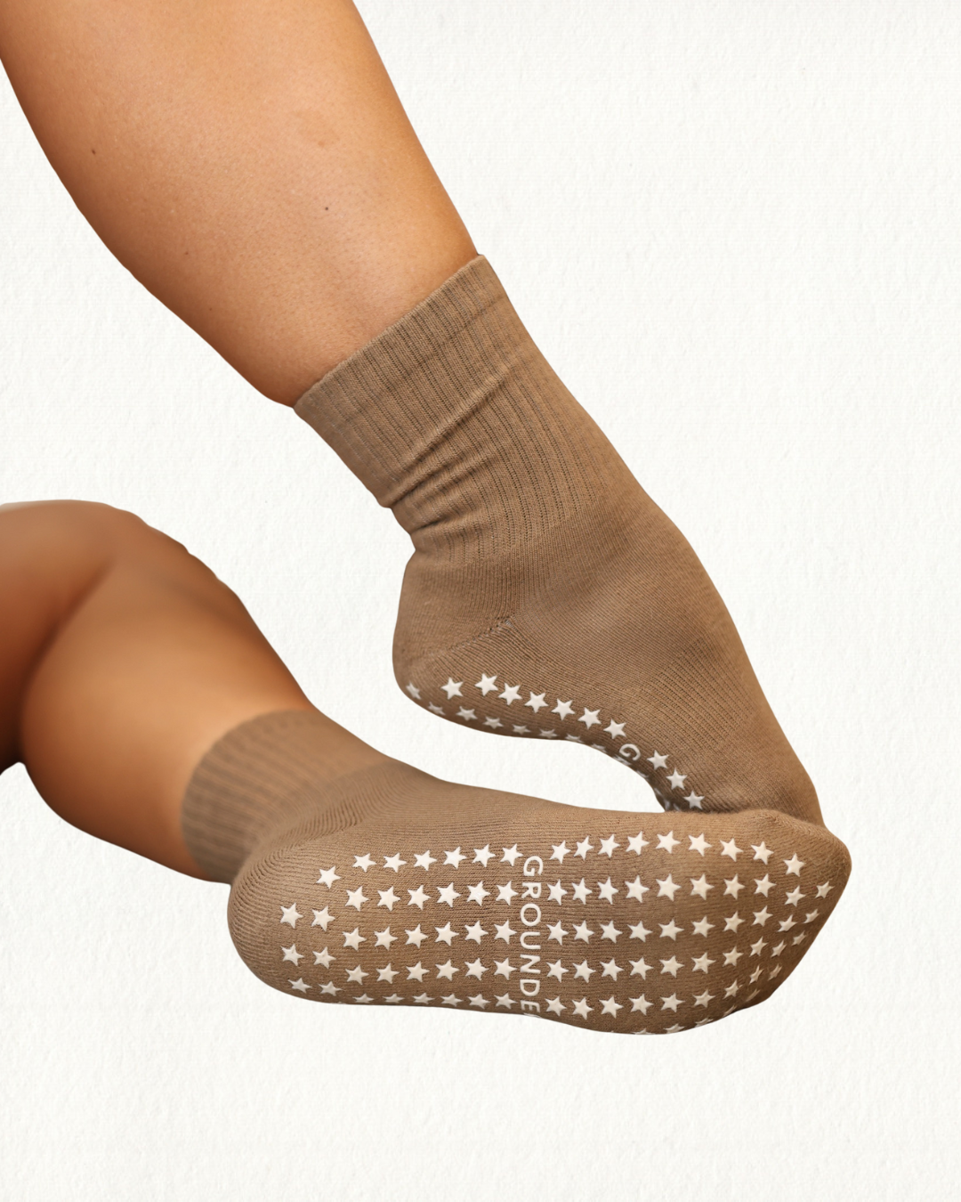 Brown pilate grip socks with star patterns on a white background