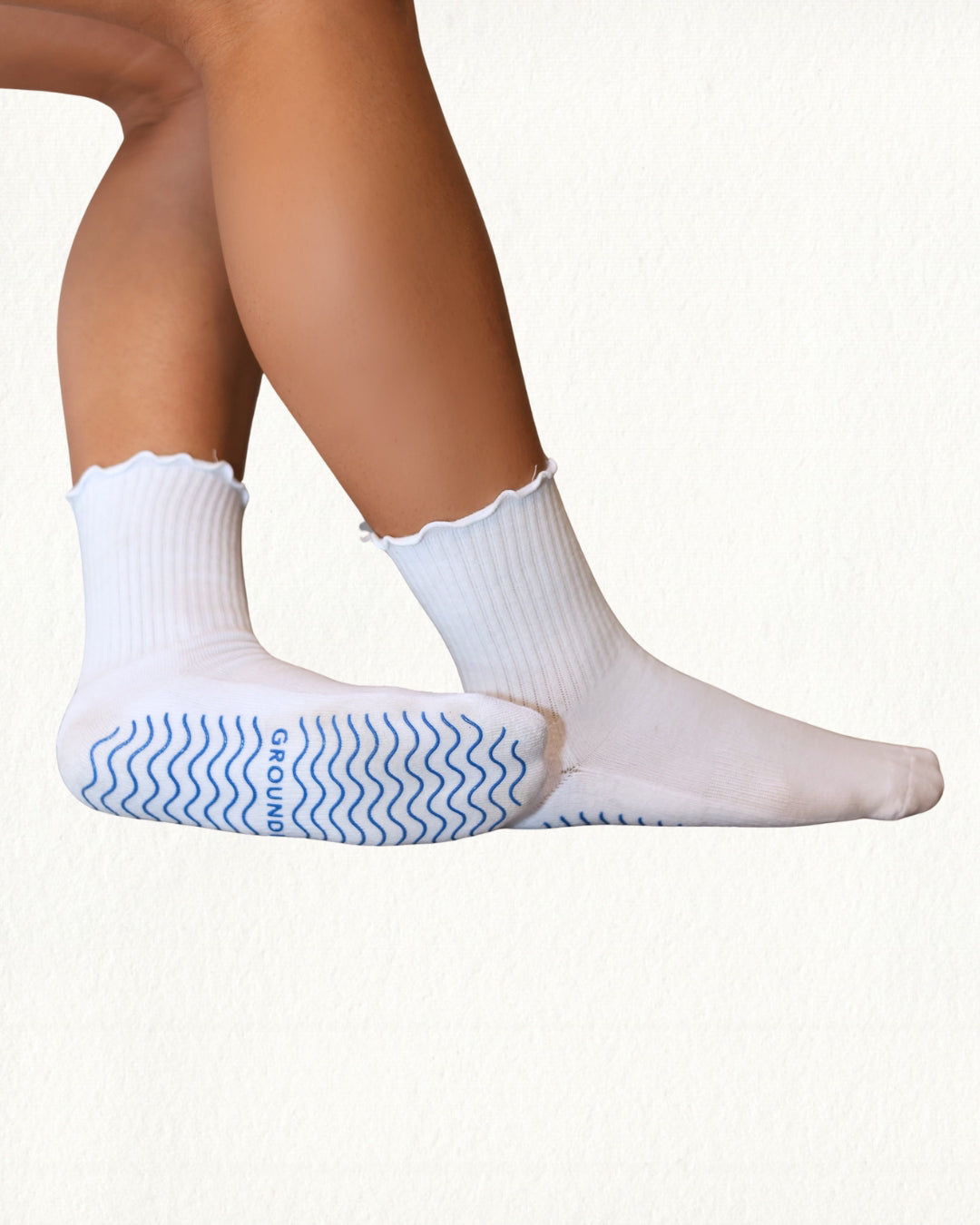 White ruffle pilates socks with blue textured sole on a white background