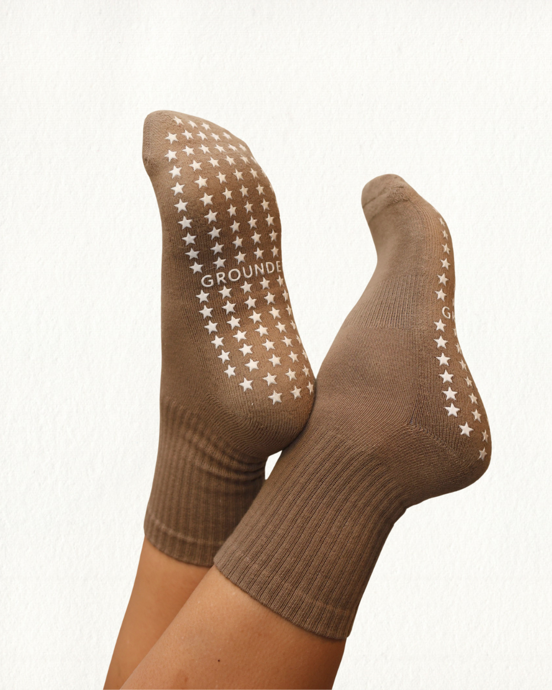 Brown yoga socks with star pattern on a white background