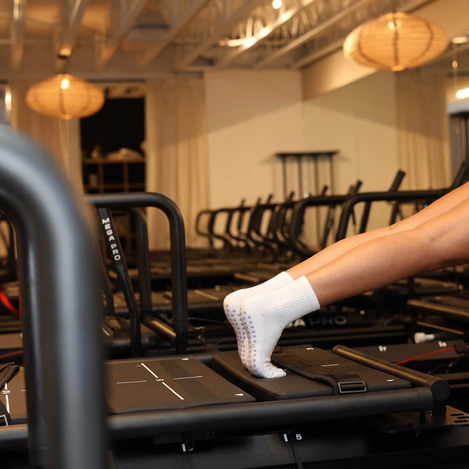 Person on a reformer doing a pilates workout in grip socks.