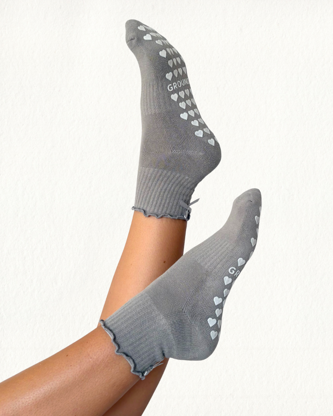 Grey pilates socks with heart patterns on a white background