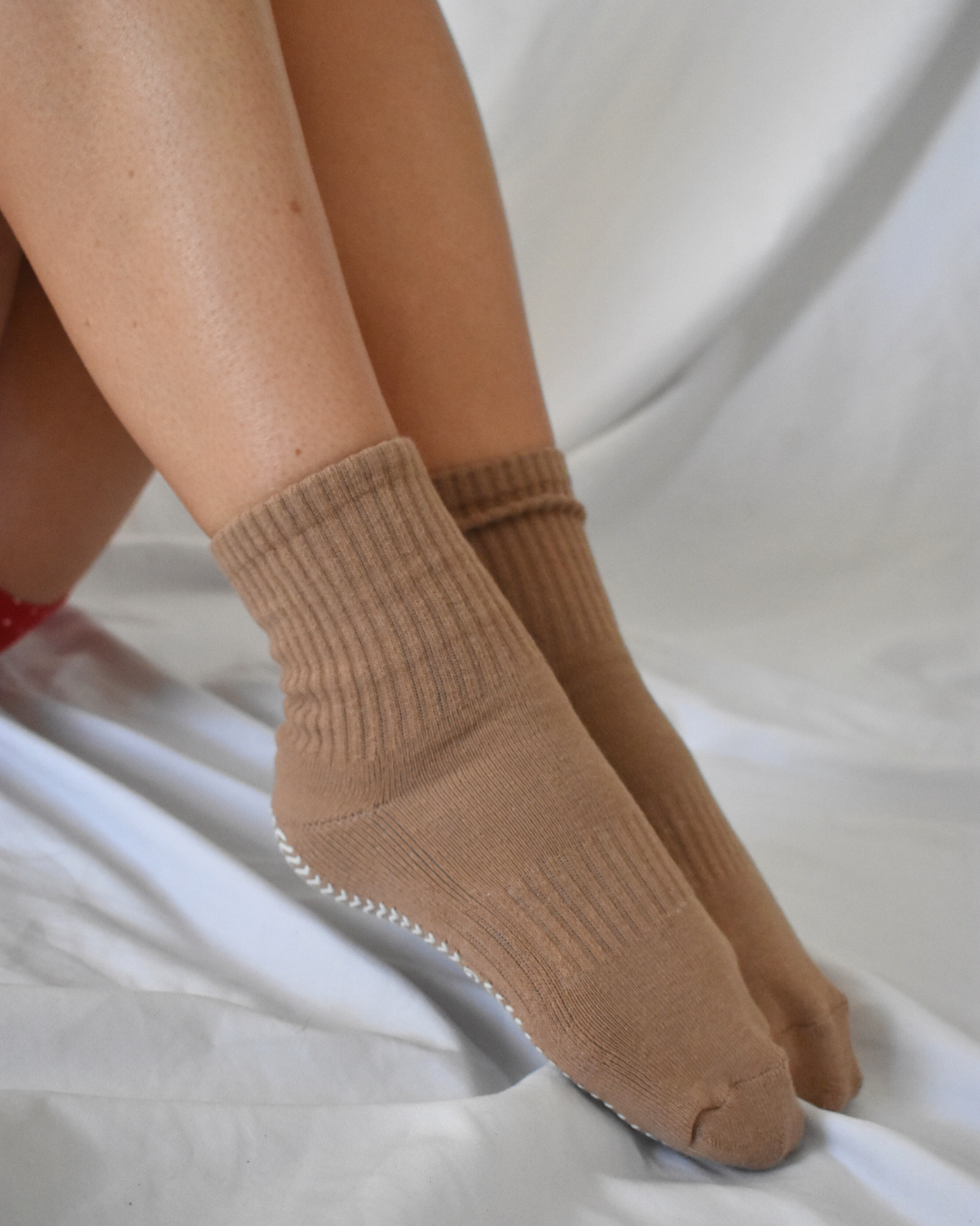 Tan grip socks socks worn on a white background