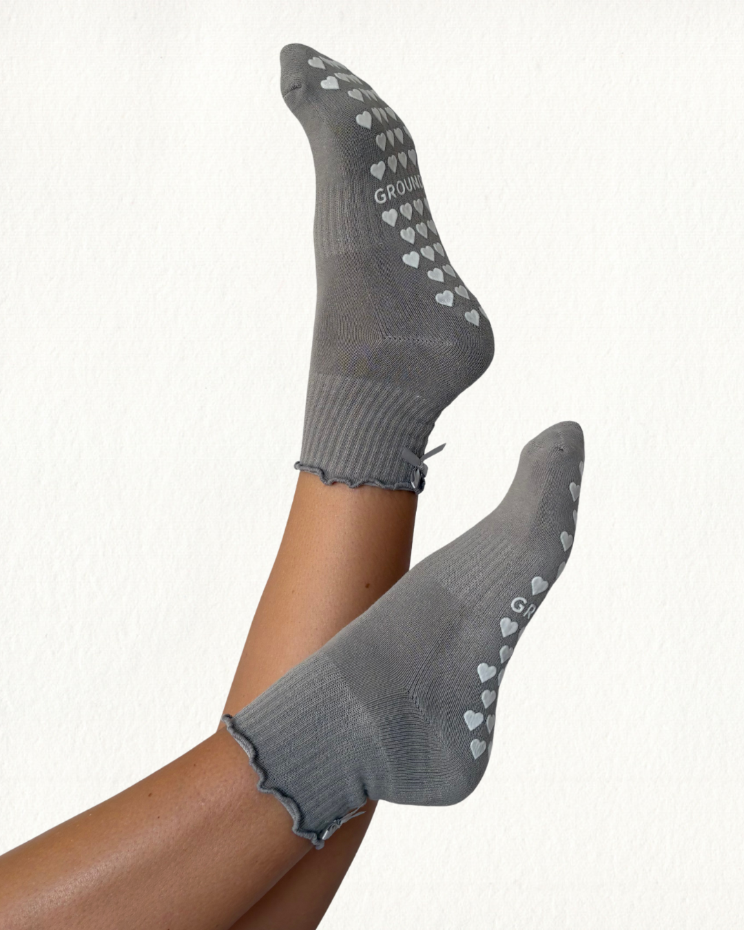 Grey pilates socks with heart patterns on a white background