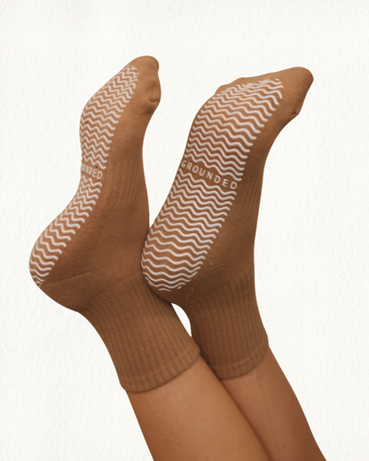 Brown Pilates socks with patterned grip on a white background