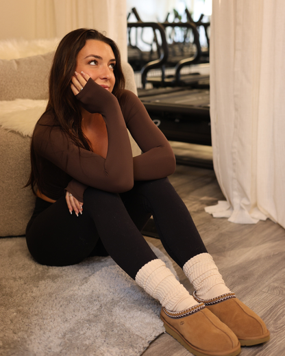Woman sitting on the floor wearing brown shoes and beige scrunch grip socks