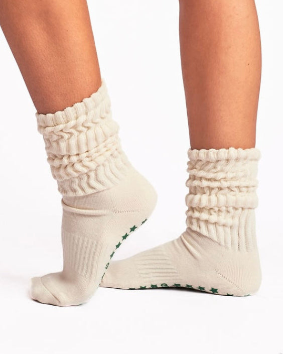 Cream slouchy pilates socks worn by a person on a white background