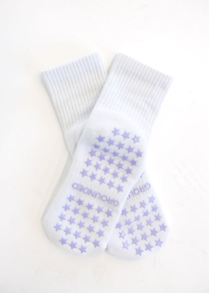 White crew grip socks with purple star pattern and brand name on a white background