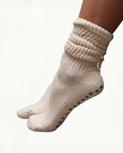 Beige scrunch Pilates socks with green star patterns on a white background